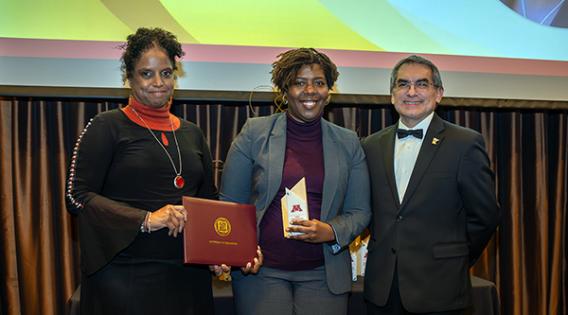 An honoree with two college administrators